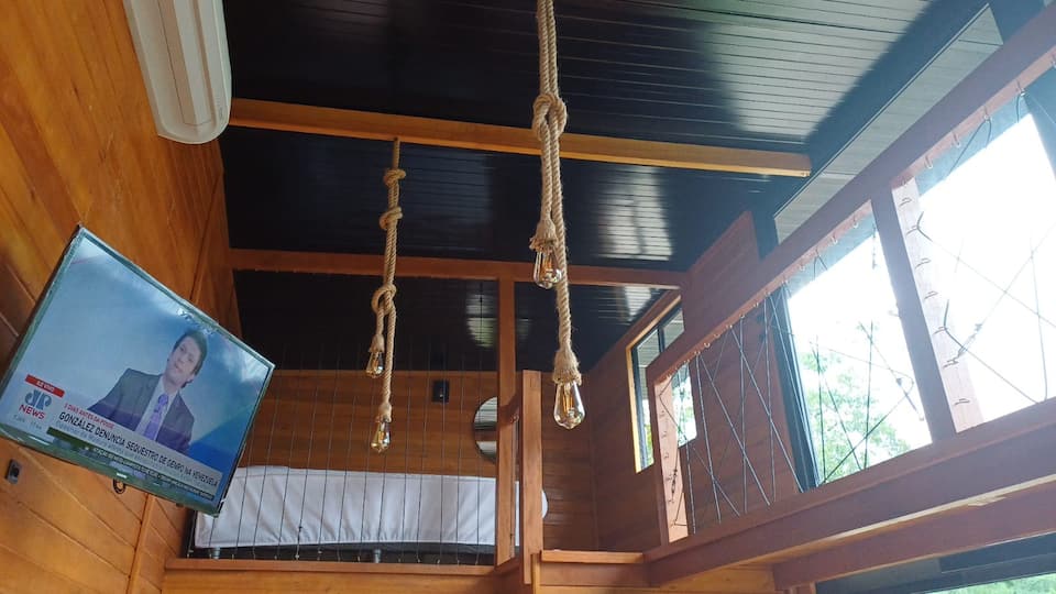 Sala da Cabana Angillyn com TV e janelas amplas